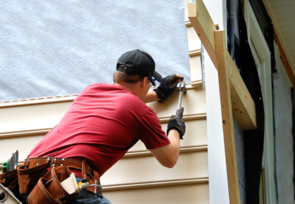 Young,homeowner,installs,siding,to,his,home.,he,is,holding