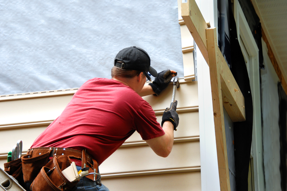 Young,homeowner,installs,siding,to,his,home.,he,is,holding